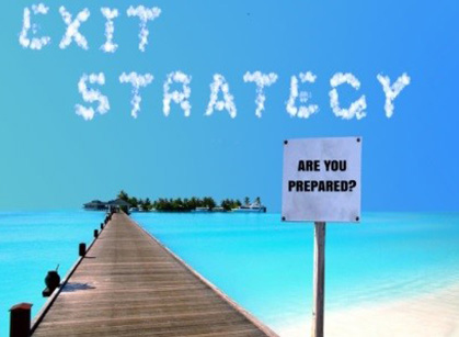 A sign that says exit strategy and is on the beach.